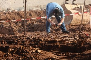KASSEL, GERMANY - JANUARY 25:  Forensics expert Jonathan Kraehahn of the University of Giessen photographs human remains in a mass grave containing the remains of approximately 60 bodies discovered earlier in the week at a construction site on January 25, 2008 in Kassel, Germany. A factory producing tanks for the Nazis occupied the site during World War II, though forensic examiners say initial investigations lay doubt to the claim that the bodies are of slave labourers who worked at the factory. One examiner said that initial observations of the dental characteristics of the skeletons indicate the bodies date older than from World War II. He also said the cause of death was likely from disease, possibly tuberculosis.  (Photo by Sean Gallup/Getty Images)